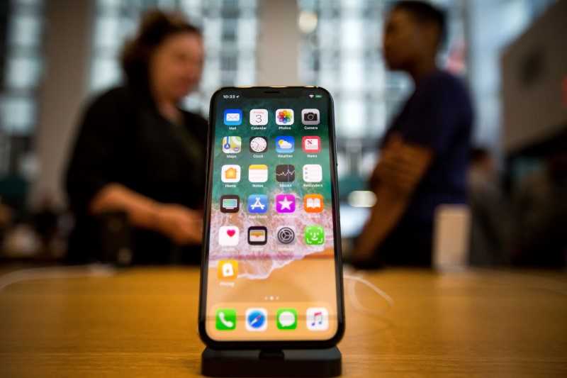 Picture of an iphone with two people in the background